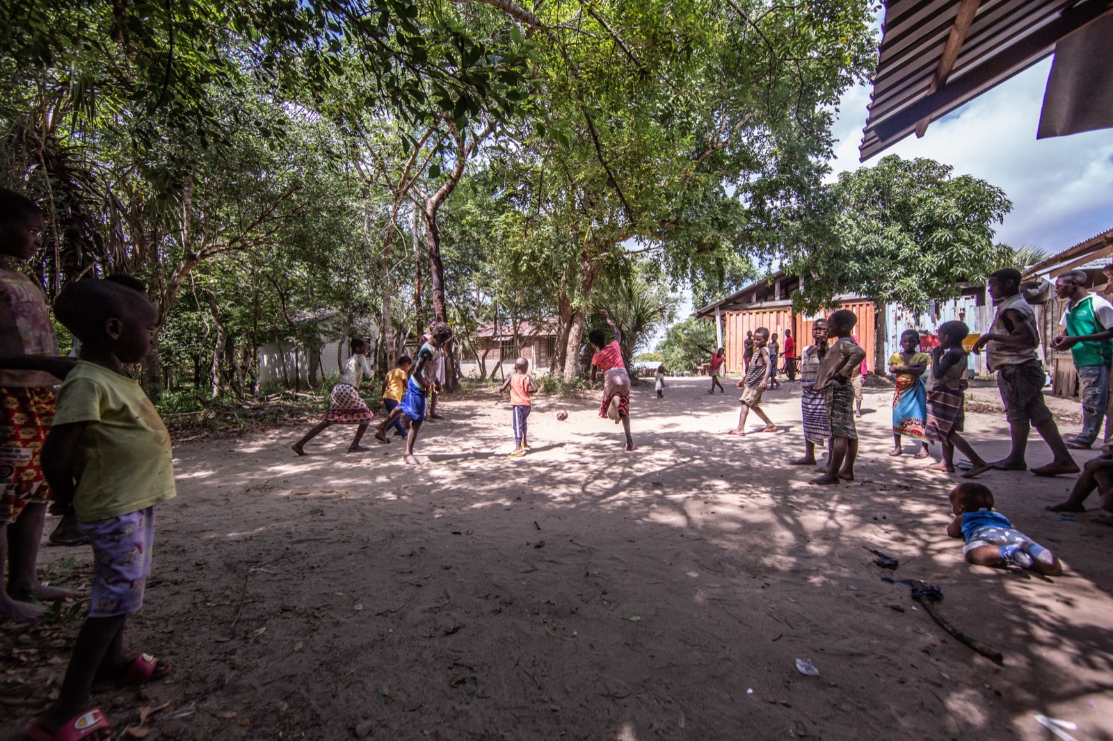 Children playing football in a village in the LevasFlor landscape